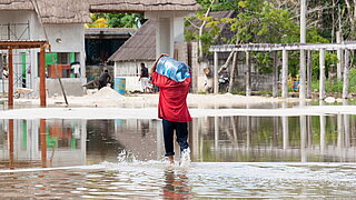 Mann trägt Wasserflasche durch Hochwasser