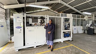 Eine Frau steht vor einer Kühlanlage