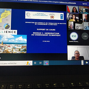 Bildschirm auf dem eine Präsentation und Teilnehmende des Online-Kurses zu sehen sind. Auf dem Bildschirm steht auf Französisch:Animation von Ausbildungsmodulen zum Thema Klimawandel.   Unterrichtsmaterial  Modul 1: Einführung in den Klimawandelt