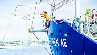 A sailing ship docks in the harbour. 