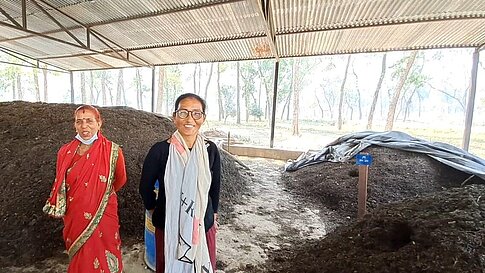 Zwei Frauen stehen in einer Anlage zur Herstellung von organischem Dünger.