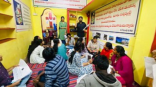 12 Freiwillige werden in einem kleinen Raum mit gelben Wänden während der Pilotphase des Urban Living Lab in Visakhapatnam geschult.