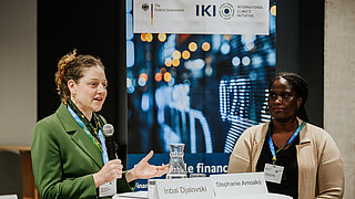 Woman speaking, with another person beside her.