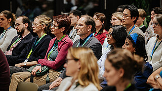 Audience members listening, photographed from the front.