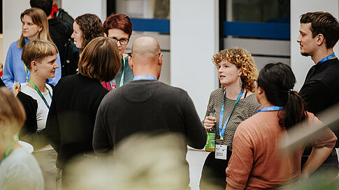 Several people conversing during a conference break.