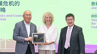 One woman and two men at a ceremony