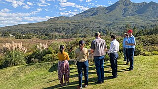 Five people are looking at the park, with mountains in the background