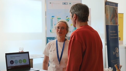 People are gathered at an information booth, talking.