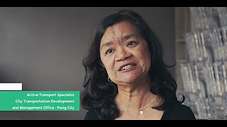 Frau mit schulterlangem, gewelltem Haar und schwarzem Oberteil vor unscharfem Hintergrund mit Regalen