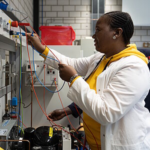 Technician at a workbench with colourful cables