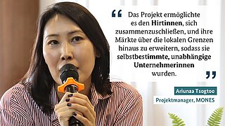 Eine Frau spricht in ein Mikrofon und erklärt ein Projekt, das Frauenhirten dabei unterstützt, ihre Märkte zu erweitern und zu unabhängigen Unternehmerinnen zu werden.