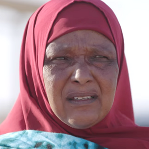 Woman wearing a red headscarf against a blurred background