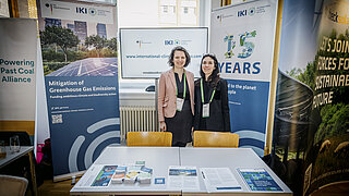 Personen an einem Infostand der Internationalen Klimaschutzinitiative. 