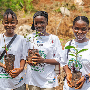 Eine Gruppe junger Frauen pflanzt Bäume im Rahmen einer Umweltbildungs- und Wiederaufforstungsinitiative.