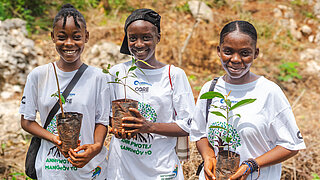 A group of young women planting trees as part of an environmental education and reforestation initiative.