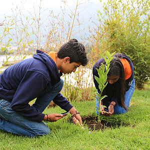 Two children planting a tree 