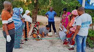 Eine Gruppe von Menschen erhält eine Schulung am Strand.