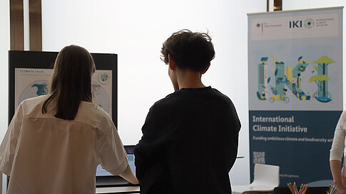 People are gathered at an information booth, talking.