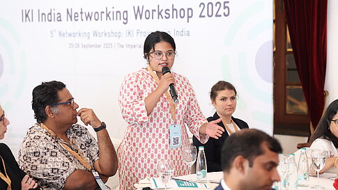 Eine Frau macht bei einer Veranstaltung einen Redebeitrag. 