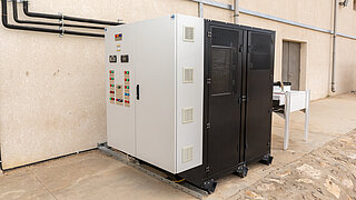 A refrigeration system with multiple switches and indicators mounted on a wall in an outdoor area.