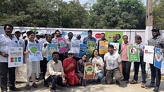 Bewohner, Freiwillige und Projektteammitglieder mit Aufklärungspostern während eines Gemeindefests in der Stadt Visakhapatnam im Februar 2025.