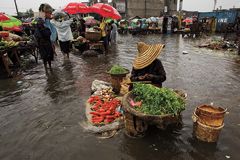 Woman sitting on a flooded market