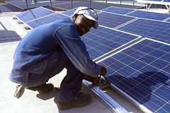Person kneeling next to solar panels