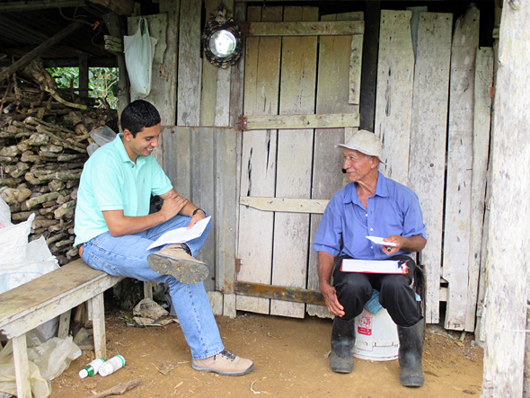Two people sitting in front of a hut
