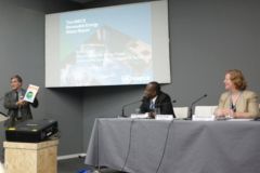 Drei Personen bei einem Vortrag.