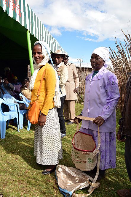 Group of people next to chairs in a tent