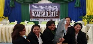 Women in front of project sign
