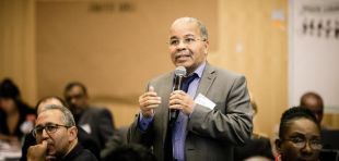Two workers wearing safty helmets cleaning solar panels on a rooftop 