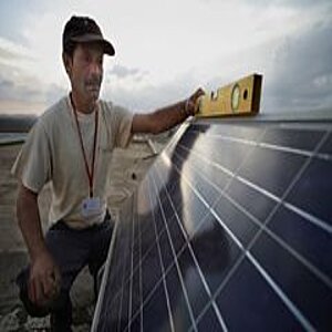 Techniker hält Wasserwaage auf Solarpanel