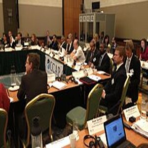 Konferenzraum voller Menschen an Tischen