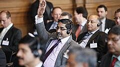 Ein Mann meldet sich in einer Gruppe sitzender Menschen 