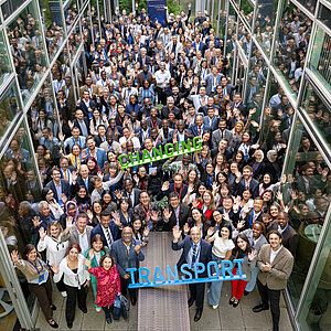 Eine Gruppe von Menschen winkt in die Kamera. 