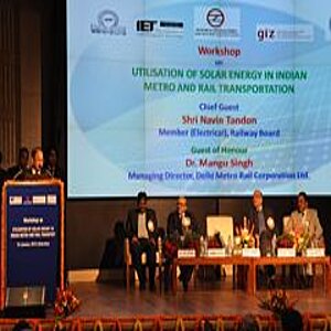 1 Mann steht am Rednerpult, 4 Männer sitzen auf Podium