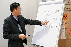 Ein Mann erklärt Daten an einer Wandtafel