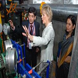 Ein Mann und zwei Frauen betrachten eine Maschine 