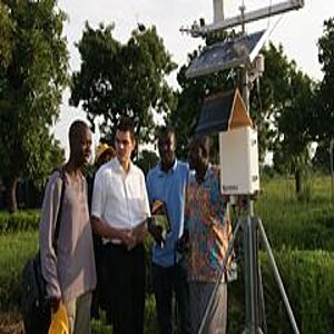 A group of men next to a weather station