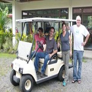 Vier Personen vor einem solarbetriebenen Golf-Cart